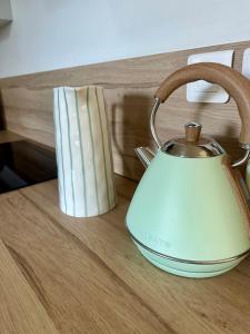 einen Wasserkocher auf einem Holztisch in der Unterkunft Le Perrées cottage Peace and Tranquility in Juaye-Mondaye