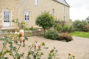 ein Backsteinhaus mit Garten davor in der Unterkunft Le Perrées cottage Peace and Tranquility in Juaye-Mondaye