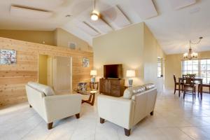 a living room with two white chairs and a table at Pet-Friendly Port St Lucie Home - 7 Mi to Beaches! in North River Shores