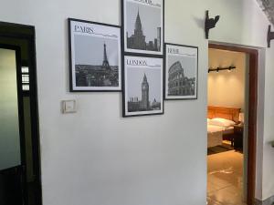 eine Wand mit Bildern von Städten darauf in der Unterkunft Elegance Cottage in Nikawatawana