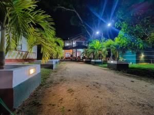 ein Haus mit Palmen und eine Straße in der Nacht in der Unterkunft Elegance Cottage in Nikawatawana