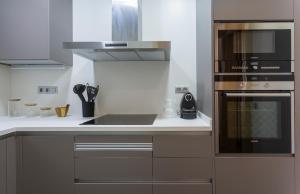 uma cozinha com um lavatório e um fogão forno superior em Apartament Major 33 em Arbós