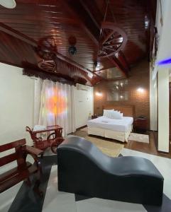 a living room with a bed and a couch at Motel Pousada do Cowboy in Sao Paulo
