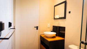 a bathroom with a bowl sink and a mirror at Noite Estrelada Hospedagem Rural & Motorhome Park in Holambra +67 photos