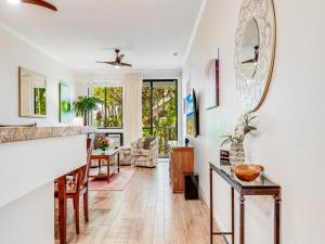 a living room with white walls and a mirror at Wailea Grand Champions 183 in Wailea