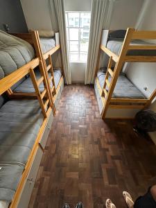クリチバにあるGup Hostelのウッドフロアの客室で、二段ベッド3組が備わります。 +36枚の写真