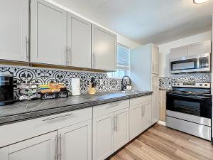 ジャクソンビルにあるSpacious 4-BR Home, 7 miles to TIAA Bank Fieldの白いキャビネットとコンロ付きオーブンを備えたキッチン