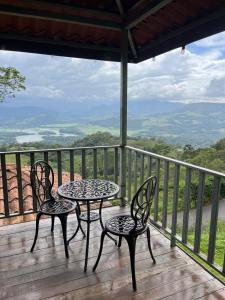 two chairs and a table on a deck with a view at Cabaña Doña Flor in Turrialba +11 photos