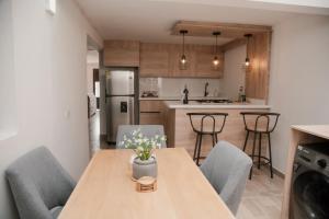 a kitchen and dining room with a wooden table and chairs at Apartamento en Rionegro, Cerca al aeropuerto JMC in Rionegro +23 photos