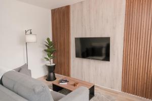 a living room with a couch and a tv on a wall at Apartamento en Rionegro, Cerca al aeropuerto JMC in Rionegro