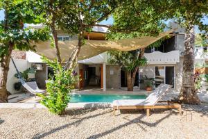 una casa con piscina y hamaca y arboles en Unmatched Modern PH Loft in the Center of la Punta, en Brisas de Zicatela