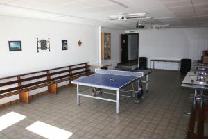 a room with a ping pong table and benches at La Cordée in Ovronnaz