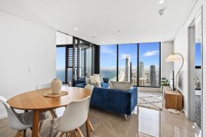 a living room with a blue couch and a table at Oceans Suites - Q Stay in Gold Coast