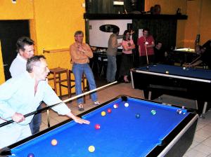 a group of people standing around a pool table at La Cordée in Ovronnaz