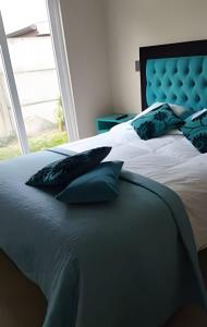 プエルトモントにあるCasa cómoda y espaciosa en Puerto Monttの枕が置かれたベッドのある寝室