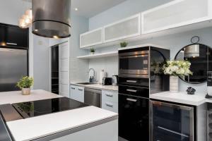a kitchen with black appliances and white cabinets at Glamorous City Escape King Bed & CN Tower Views in Toronto