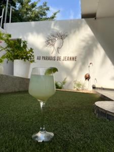 a margarita in a glass sitting on the grass at Au Paradis de Jeanne in Ngaparou