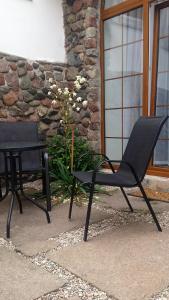 コウォブジェクにあるGawraの黒い椅子2脚と建物前のテーブル