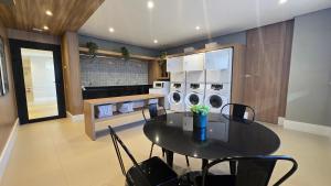 a kitchen with a table and a kitchen with washing machines at Studio em Sorocaba no Campolim in Sorocaba