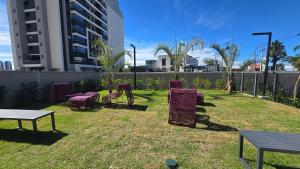 a group of chairs sitting on the grass in a yard at Studio em Sorocaba no Campolim in Sorocaba