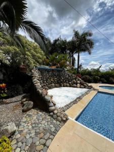 a swimming pool with a rock retaining wall next to a resort at Hotel Campestre Ranchón Baquero in Acacías