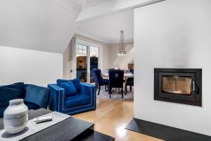 トロムソにあるBraMy Apartments The Aurora LUX Viewの青いソファと暖炉のあるリビングルーム