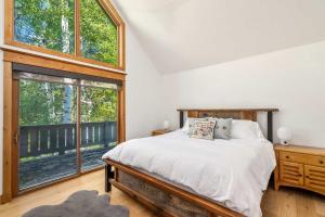 a bedroom with a bed and a large window at Evergreen Escape - Home for 12 in Mid Vail