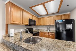 cocina con fregadero y nevera negra en Greens at Copper 217 by Summit County Mountain Retreats, en Copper Mountain 27 fotos más