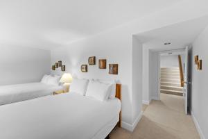 a white bedroom with two beds and a doorway at Saints John 2520 by Summit County Mountain Retreats in Snake River Health Services Incorporated Heliport +22 photos