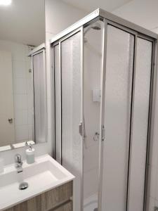 a bathroom with a shower and a white sink at Depto Estudio Full equipado con Estacionamiento in Concepción