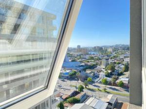 a view of a city from a window of a building at Depto Estudio Full equipado con Estacionamiento in Concepción