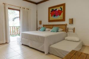 a bedroom with a large bed and a window at Pousada Bellissima in Boicucanga +86 photos