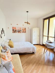a white bedroom with a bed and a couch at Casa Sole, 10 minutes from Lake Como in Lurate Caccivio