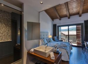 1 dormitorio con cama, lavabo y bañera en Bonansa Country Hotel, en Bonansa