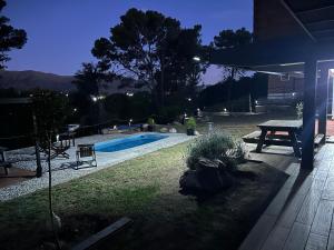 a backyard with a swimming pool and a picnic table at Departamento para 2 pers con vista a las sierras OC in Villa Giardino