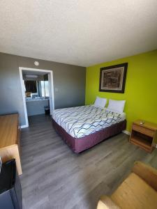 a bedroom with a bed in a room with green walls at Lamplighter Inn Independence in Independence