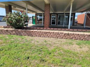 a brick retaining wall in front of a building at Lamplighter Inn Independence in Independence +9 photos