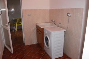 フォンターネ・ビアンケにあるLa Piccola Musaのバスルーム(洗濯機、シンク付)
