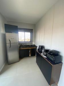 an empty kitchen with a refrigerator and a sink at Essence 401 in Navegantes