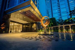 a large building with a sculpture in front of it at Arvesto Jakarta in Jakarta