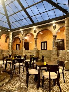 a restaurant with tables and chairs and a glass ceiling at Ayni Boutique Hotel in Cusco