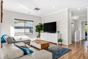 Una sala de estar con un sofá y un televisor. en Beach Gum., en Apollo Bay