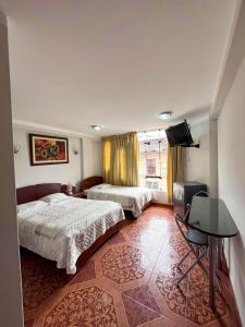 a hotel room with two beds and a table at Retamas Hotel in Cajamarca +22 photos