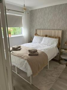 ein Schlafzimmer mit einem Bett mit zwei Handtüchern darauf in der Unterkunft Home on the Broads Just Renovated in Lowestoft + 82 Fotos