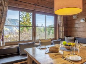 a dining room with a table and chairs and windows at Yosi im Brixental in Wörgler Boden