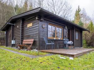 a log cabin with a deck and two chairs at Yosi im Brixental in Wörgler Boden