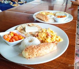two plates of food on a wooden table at Finca Tradicional La Rochela in Montenegro