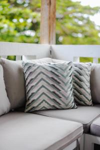 a white couch with two pillows on a porch at Serenity Rincon Guesthouse in Rincon