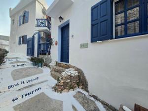 a white house with blue doors and a staircase at Agla Studio 2 in Fourni Ikarias