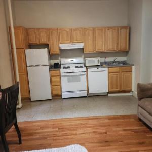 a kitchen with white appliances and wooden cabinets at New York City GuestHouse in New York